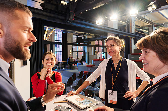 Vier Menschen stehen bei der Veranstaltung Dimension Digitalisierung – Digital unterwegs im Ganztag im Gegenlicht zusammen und unterhalten sich. © Florian Freund
