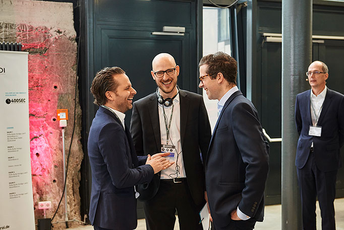 Eine Gruppe Menschen unterhält sich fröhlich be mi einen Event der Firma ROI Management Consultanting, Veranstaltungsfotografie, © Florian Freund