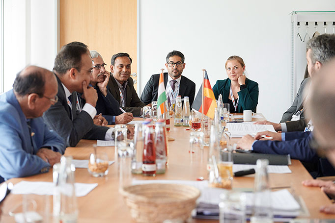 Verschiedene Vertreter*innen aus Indien und Deutschland beim Indo German Energy Dialouge an einem Tisch sitzen, Konferenzreportage, © Florian Freund