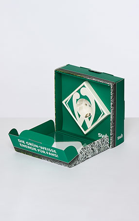 Eine Steckdose mit dem Logo von Werder-Bremen, als Geschenk für Ökostromkund*innen. Enstanden für das Buch 25 Jahre Typonauten.